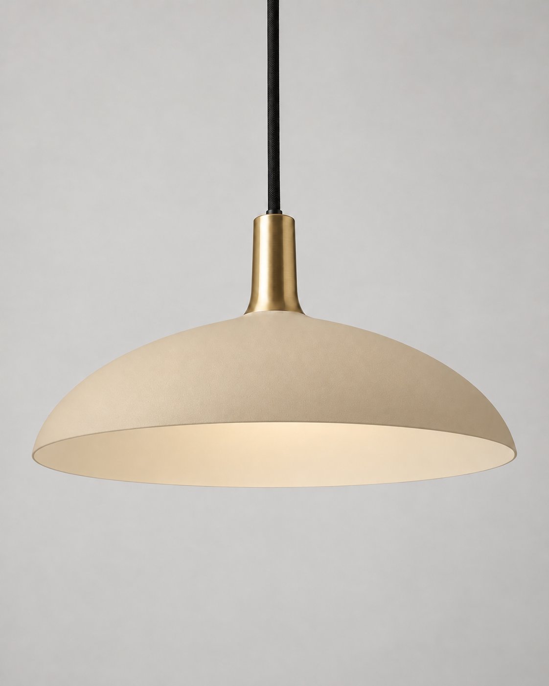 Forma pendant light in sand with a brass neck and black suspension cord